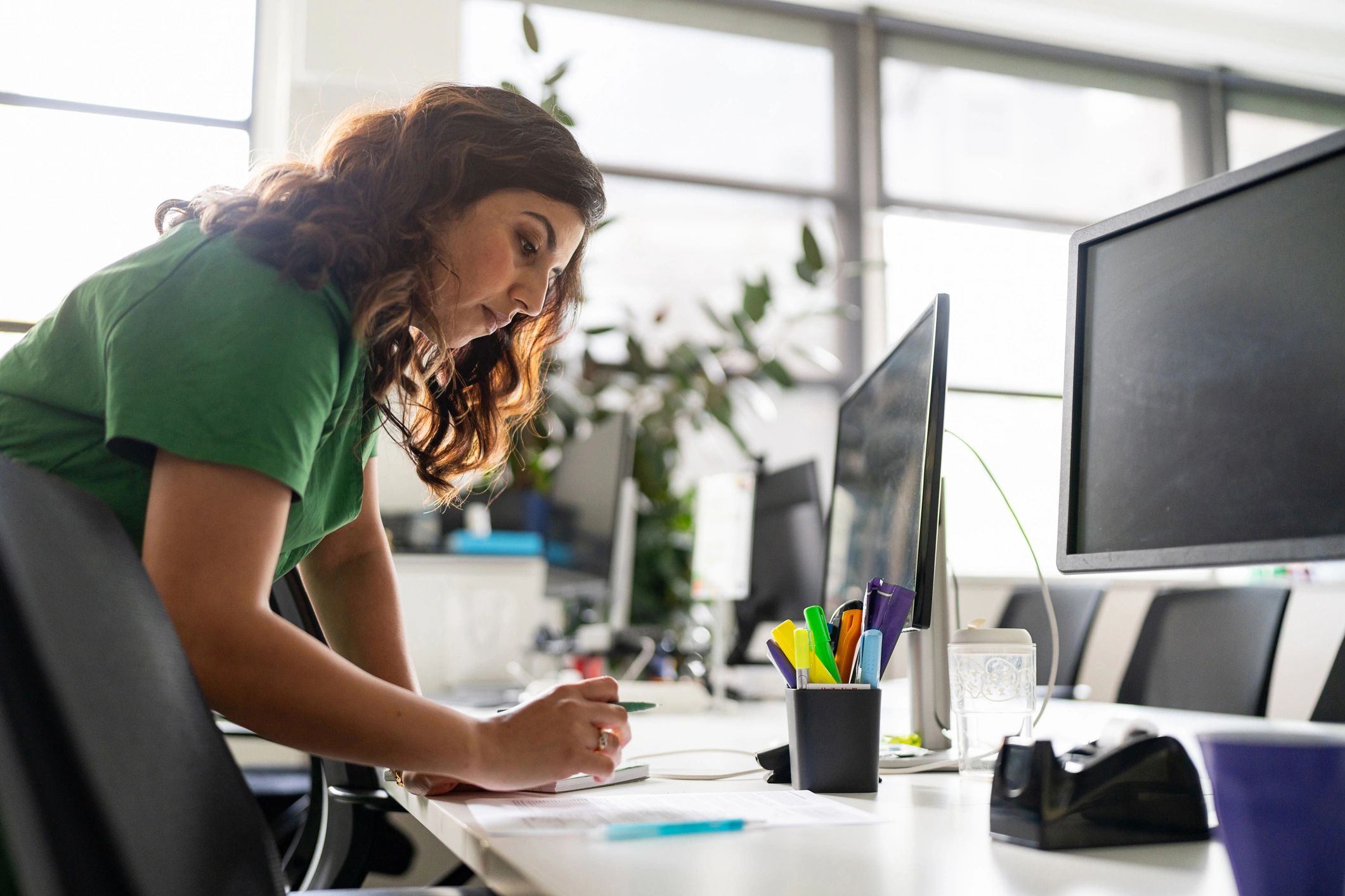 Content professional working at a desk with planning materials